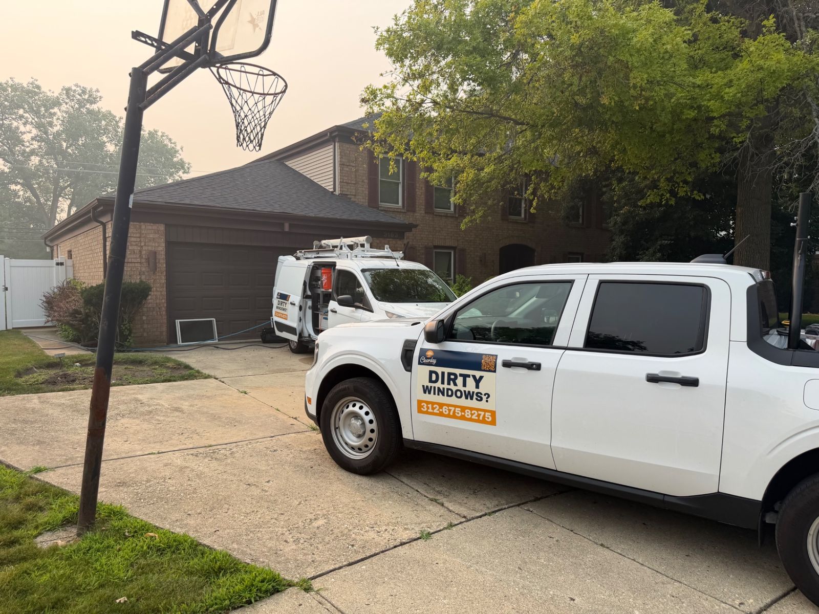 ClearDay van and truck at a suburban home window cleaning job