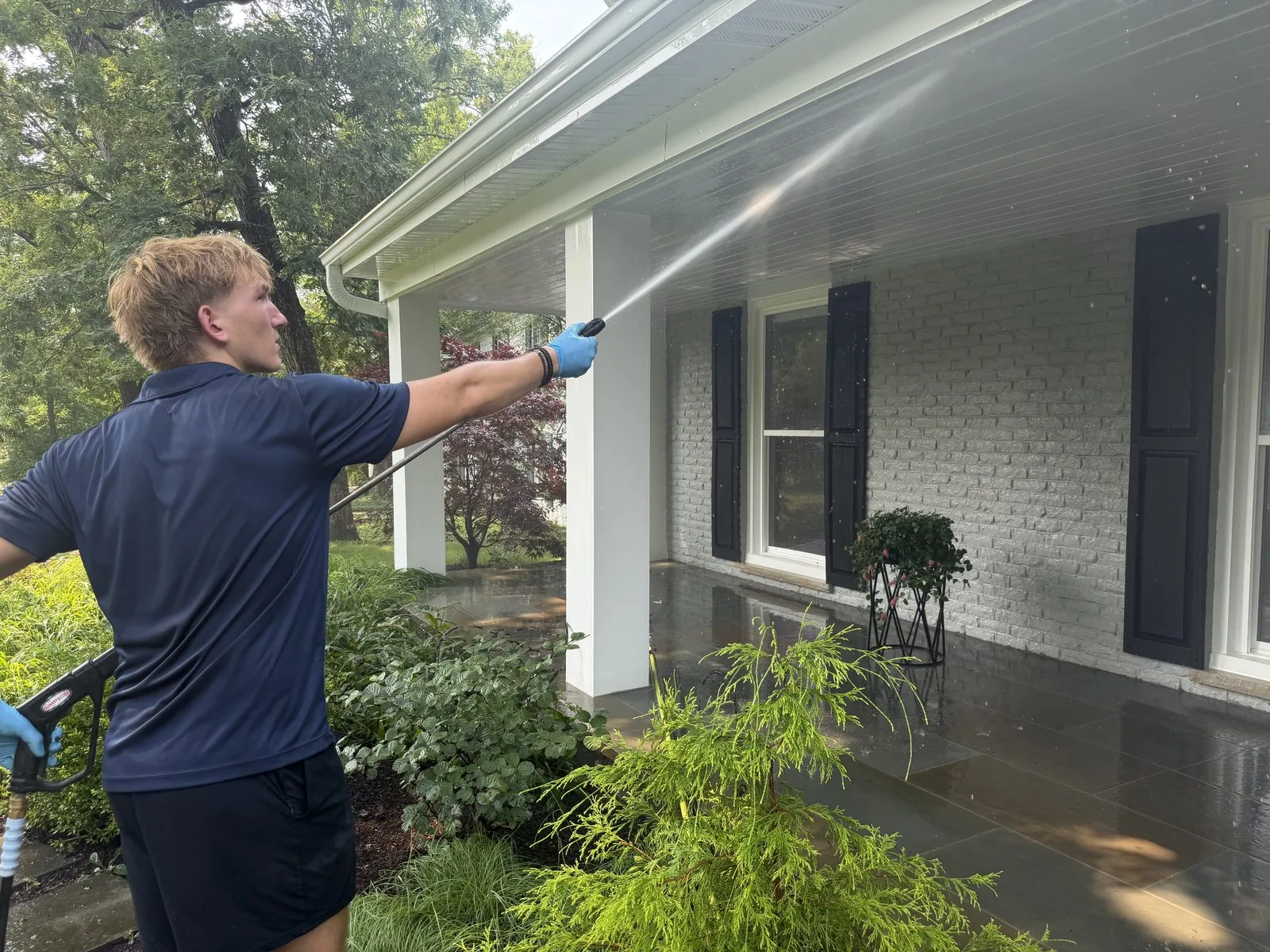 ClearDay technician soft washing a covered porch on a Northwest Suburbs home