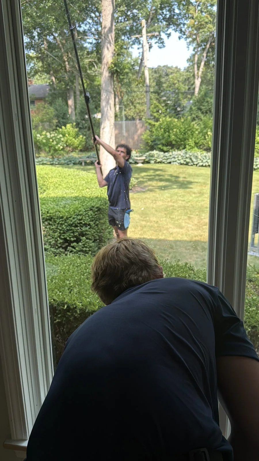 ClearDay technicians cleaning interior and exterior windows together at a Northwest Suburbs home