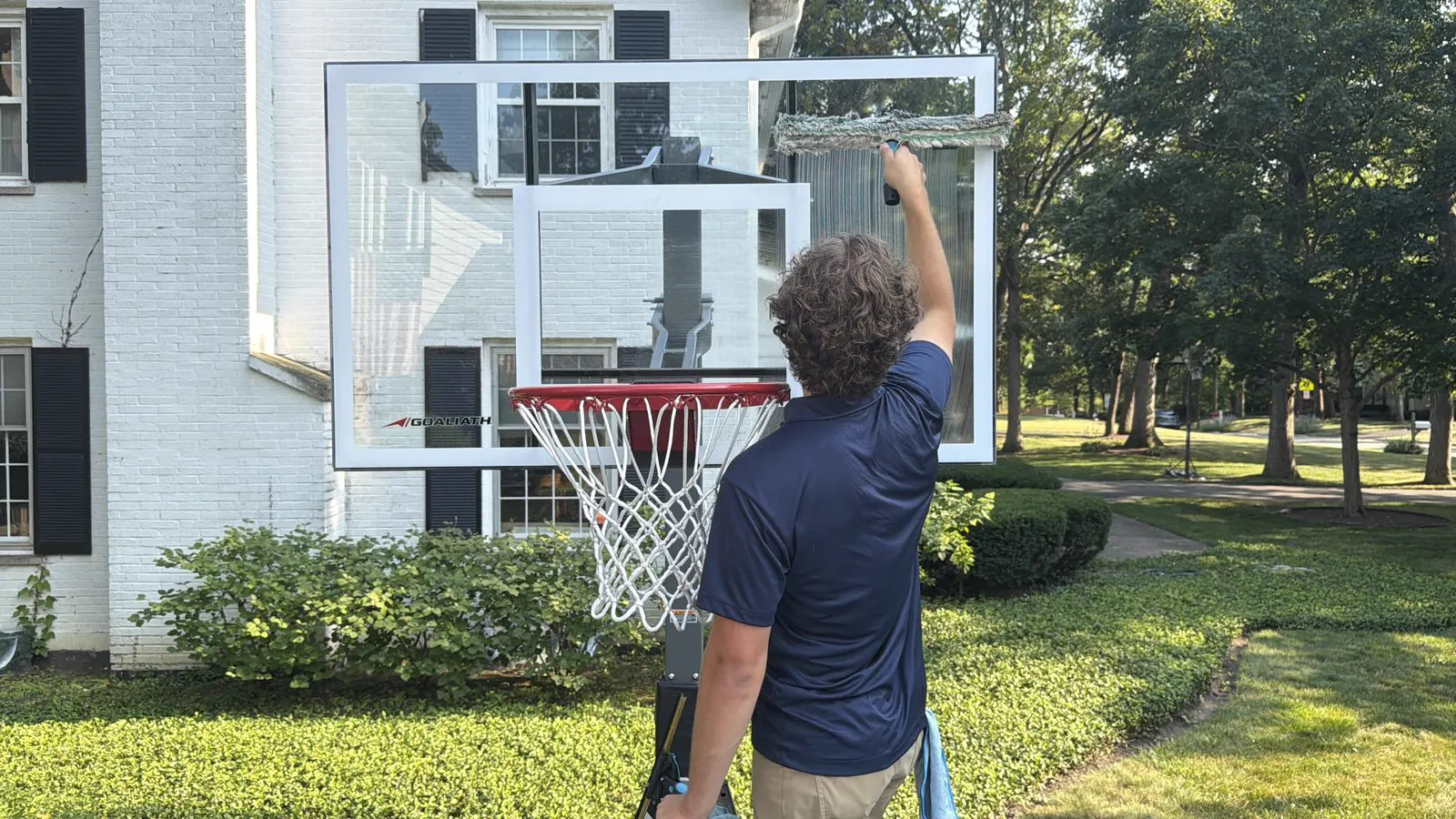 ClearDay technician detailing glass beside a basketball hoop during window cleaning