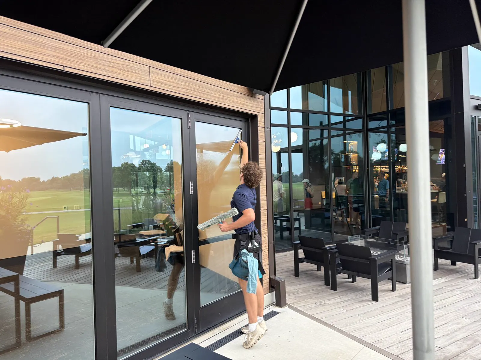 ClearDay technician cleaning commercial glass doors during interior window cleaning