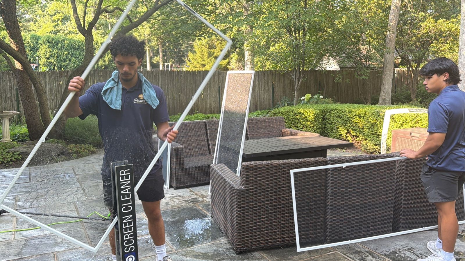 ClearDay team hand-washing window screens with a screen cleaning machine