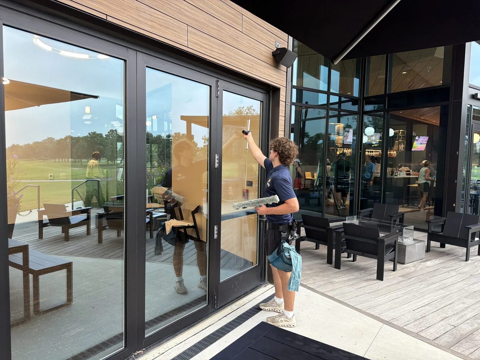 ClearDay technician using a squeegee during exterior window cleaning